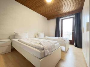 two beds in a room with a window at TEU101 komfortable Monteurwohnung in Teublitz