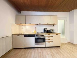 a kitchen with white cabinets and a stove top oven at TEU101 komfortable Monteurwohnung in Teublitz