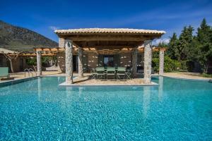 a swimming pool with a gazebo and blue water at Βίλα Αοιδή in Galaxidi