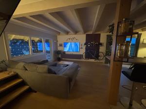 a living room with a couch and a tv at Black Forest Sports Loft in Achern