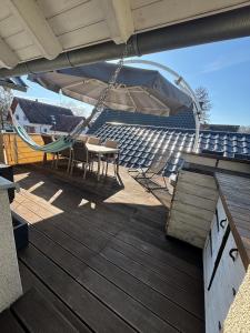 a deck with a table and chairs and an umbrella at Black Forest Sports Loft in Achern