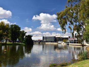 a view of a river with buildings in the background at Andela Guesthouse in Bloemfontein