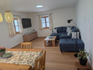 a living room with a blue couch and a table at Rieplhof in Samerberg