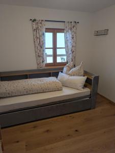 a bed in a room with a window at Rieplhof in Samerberg