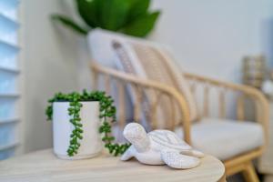 a wooden table with a pair of shoes on a chair at Seashells - 3BR Marcoola Beach Resort in Marcoola