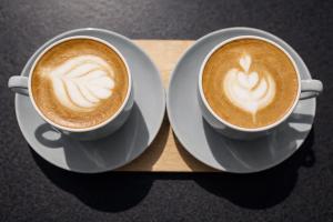 two cups of coffee sitting on a wooden tray at HoTEL METRoVIEW in Bahādurgarh +21 photos