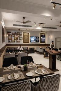 a restaurant with a table and chairs and people in the background at HoTEL METRoVIEW in Bahādurgarh