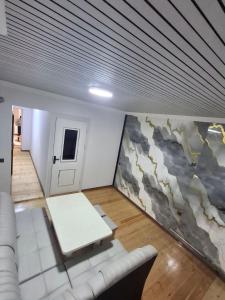 a living room with a white couch and a wall at BridgeStayHostel in Samarkand