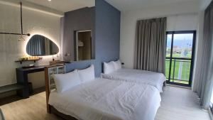 a hotel room with two beds and a window at MM No6 Villa in Luodong