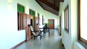 a hallway with chairs and a table in a building at Monsoon Villa in Puttalam