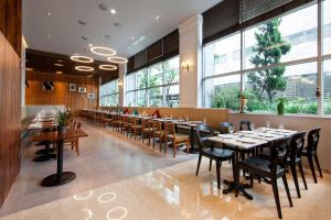 a restaurant with tables and chairs and large windows at Hotel Atrium Jongno in Seoul