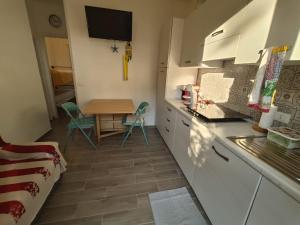 a kitchen with white cabinets and a table with chairs at Piazzetta 293 in Rosolina Mare