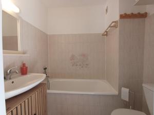 a bathroom with a tub and a sink and a toilet at Studio vue mer in Cervione +10 photos