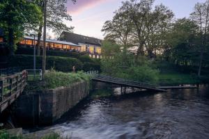 a bridge over a river with a train crossing it at Kleinhuis Hotel Mellingburger Schleuse in Hamburg