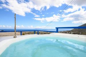 a hot tub with a view of the ocean at Fertimo Suites - Authentic Cave Homes with Private Hot Tub in Éxo Goniá