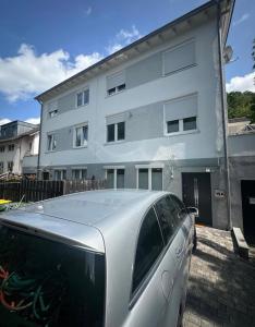 Ein Auto parkte vor einem weißen Gebäude in der Unterkunft Apart Halver in Halver