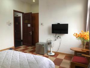 a bedroom with a bed and a fan and a tv at Motel Minh Thảo in Danang
