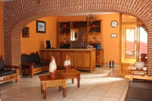 a living room with an archway and a living room with a table at Hotel Camino de Villaseca in Guanajuato
