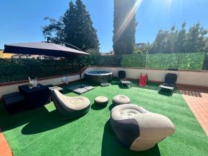 a living room with green grass and chairs and an umbrella at Empoli Charm in Empoli
