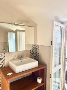 a bathroom with a white sink and a mirror at Le Mongolfiere in Mondovì