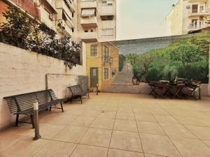 two benches sitting next to a wall with a mural at Cozy & Modern Flat for 5 in Athens in Athens