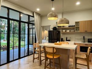a kitchen with a island with chairs and a table at Cococreek Kohkood in Ban Khlong Mat