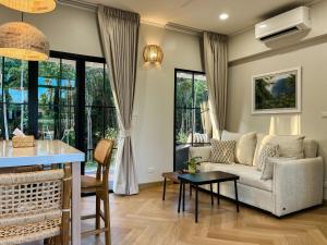 a living room with a couch and a table at Cococreek Kohkood in Ban Khlong Mat