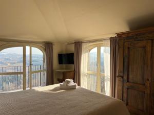 a bedroom with a bed and a large window at Le Mongolfiere in Mondovì