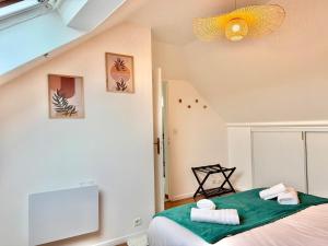 a bedroom with a bed with towels on it at Maison Bellebat - proche d'Orleans in Orléans