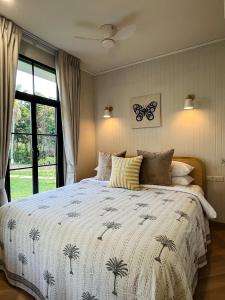 a bedroom with a bed and a butterfly on the wall at Cococreek Kohkood in Ban Khlong Mat