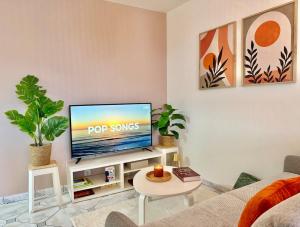 a living room with a flat screen tv on a stand at Maison Bellebat - proche d'Orleans in Orléans