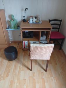 a table and a chair in a room with a desk at chez mary et bruno in Le Neubourg