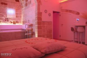 a bedroom with a bed and a sink and a tub at Dofely Suites - Tritone in Polignano a Mare +14 photos