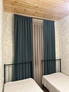 two beds in a room with blue curtains at Gudaleti Palace Private Countryside Villa near Tbilisi in Kaspi