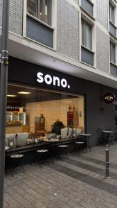 a store with tables and chairs in front of a store at Hotel am Augustinerplatz in Cologne