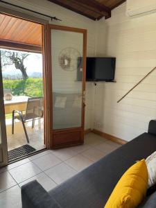 a bedroom with a sliding glass door and a television at Au Pays de Cocagne in Nyons