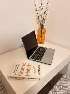 a laptop sitting on a table with a book at Yellow Dawn Modern Flat in Quiet Area with Garage Parking and Self Check-In in Rediu