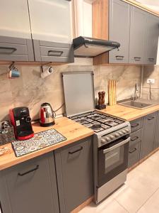 a kitchen with a stove top oven next to a sink at Yellow Dawn Modern Flat in Quiet Area with Garage Parking and Self Check-In in Rediu