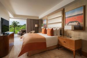 a hotel room with a bed and a television at The Mulia in Nusa Dua