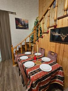 a dining room table with plates and candles on it at Gudaleti Palace Private Countryside Villa near Tbilisi in Kaspi