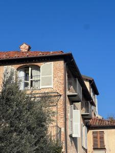 a red brick building with windows and a roof at Le Mongolfiere in Mondovì