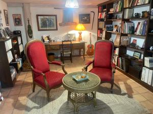 a living room with two chairs and a table at Les chambres de La Serre in Camarès