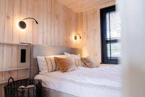 a bedroom with a bed with white sheets and pillows at Bay Zatoka Radzyń in Radzyń