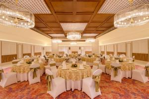 a banquet hall with tables and chairs and chandeliers at Lemon Tree Hotel, Bhubaneswar in Bhubaneshwar +72 photos