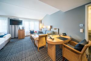 a hotel room with a couch and a table at Hotel Esplanade Resort & Spa - Adults Only in Bad Saarow