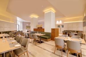a restaurant with tables and chairs in a room at Lemon Tree Hotel, Bhubaneswar in Bhubaneshwar