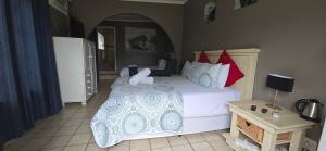 a bedroom with a large white bed with red pillows at Crayfish Creek Guest House in Richards Bay +27 photos