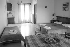 DoulianaにあるIliopetraのベッド2台、テーブル、タオルが備わる客室です。