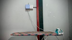 a chair with a electrical outlet on a wall at Swing & Pillows - Sentul Titiwangsa in Kuala Lumpur