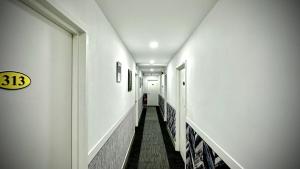 a corridor of a hallway with white walls and a long hallway at Swing & Pillows - Sentul Titiwangsa in Kuala Lumpur